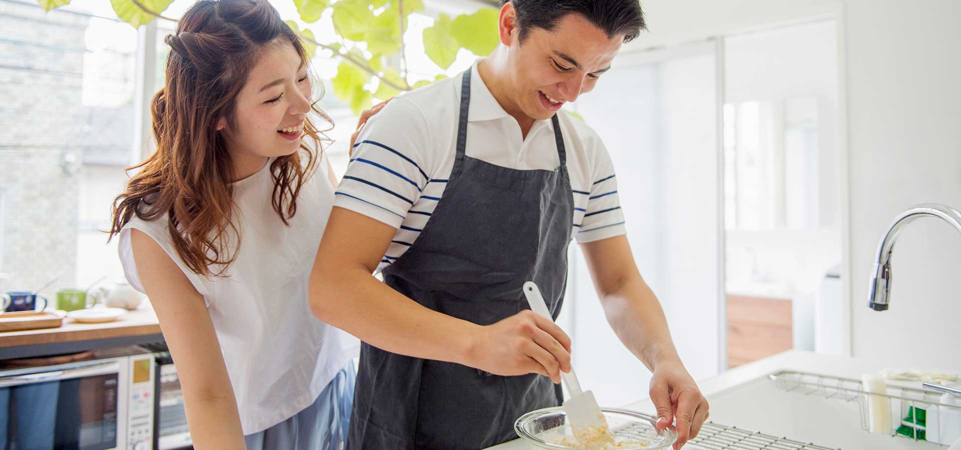 Young Asian couple cooking in the kitchen.