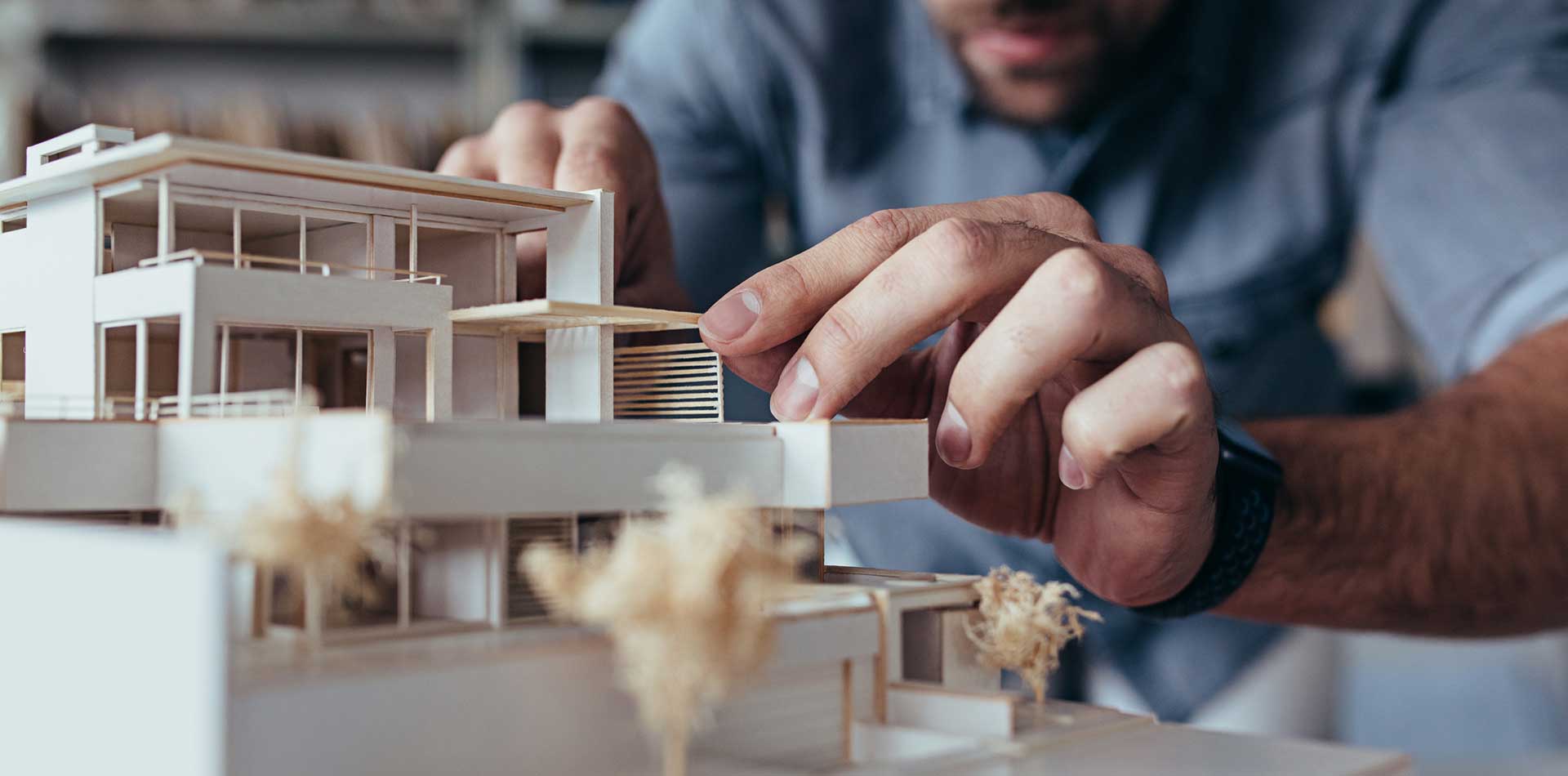 architect with balsa wood model of home on desk.